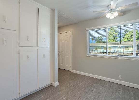 A room with a window and a ceiling fan.