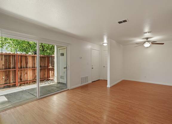 A room with wooden floors and a ceiling fan.