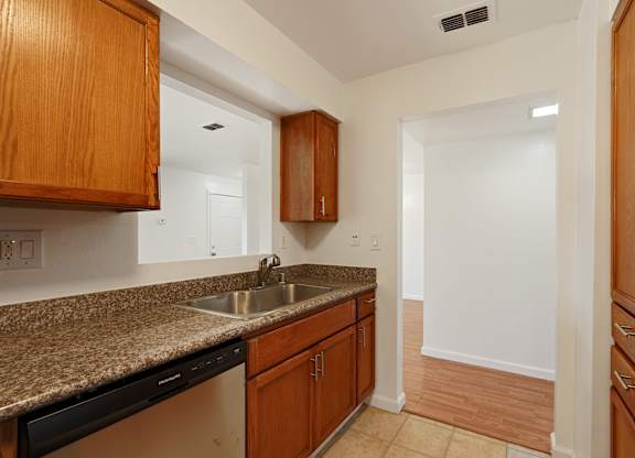 A kitchen with wooden cabinets and a granite countertop.