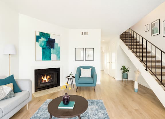 A living room with a fireplace and a blue chair.