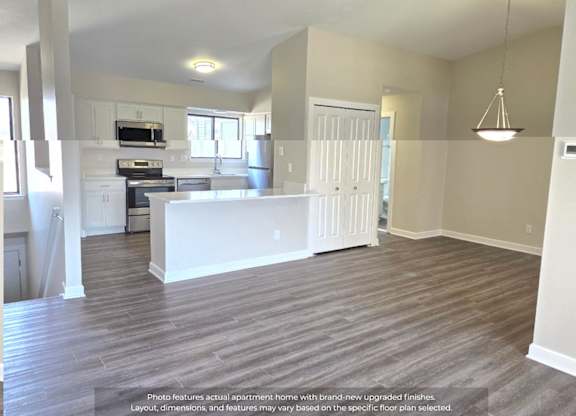 A spacious apartment kitchen with white appliances and a large island.