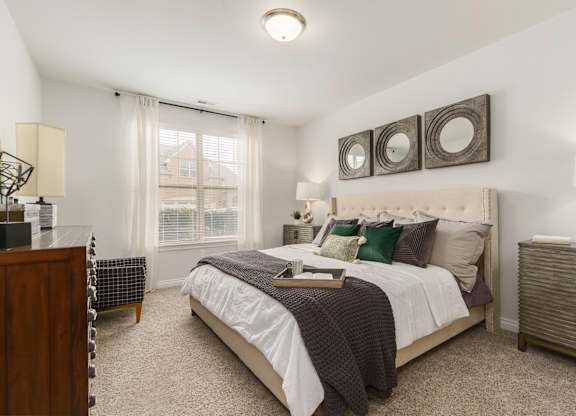 a bedroom with a bed and two mirrors on the wall