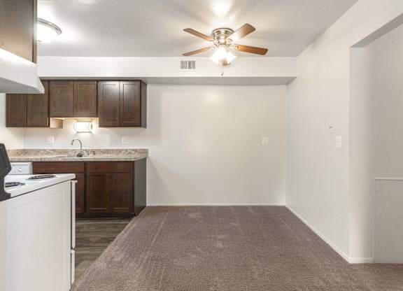 A kitchen with a white fridge and brown cabinets.