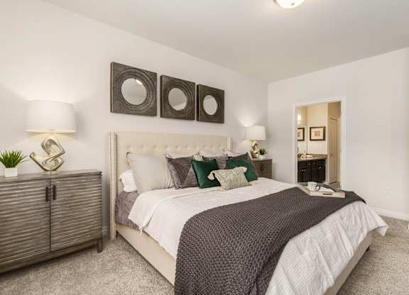a bedroom with a bed and three mirrors on the wall