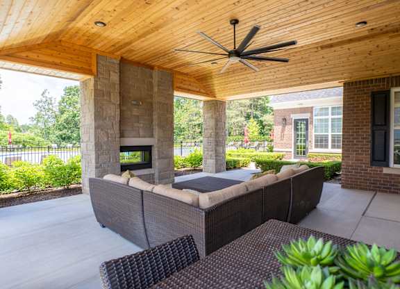 A patio with a couch and a ceiling fan.