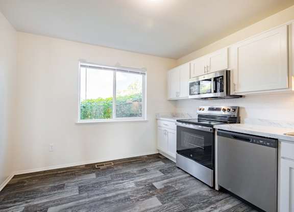 A kitchen with a stove top oven and microwave.