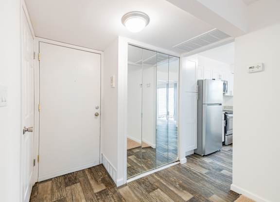 A white door is in a room with a wooden floor.
