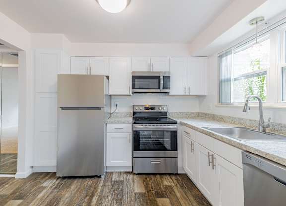 A kitchen with white cabinets and stainless steel appliances.