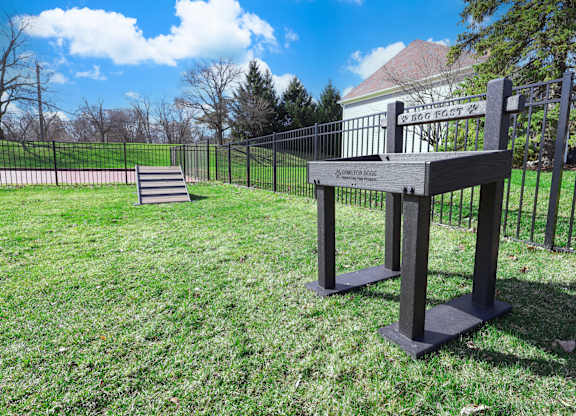 A black metal fence surrounds a grassy area with a sign that reads "Amistad Boundary".