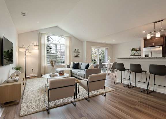 A modern living room with a large window, a dining table set for two, and a kitchen area in the background.