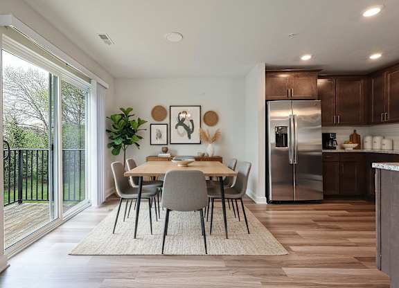 A modern kitchen with a dining table and chairs in the middle of the room.