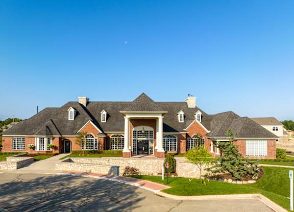 a large house with a street in front of it and a blue sky