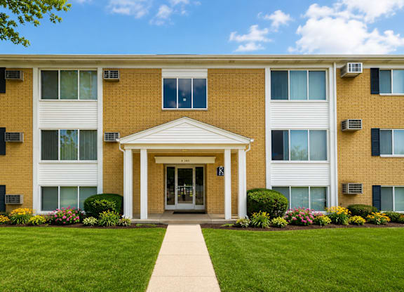 A building with a white entrance and a walkway leading to it.