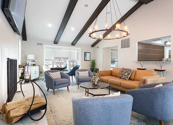 A modern living room with a large sofa, two chairs, and a coffee table.