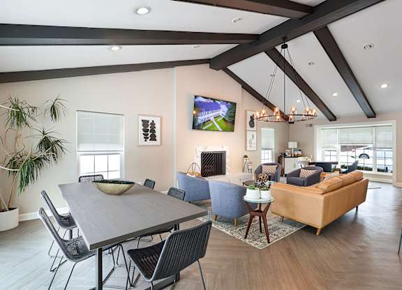 A modern living room with a large grey table and a blue sofa.