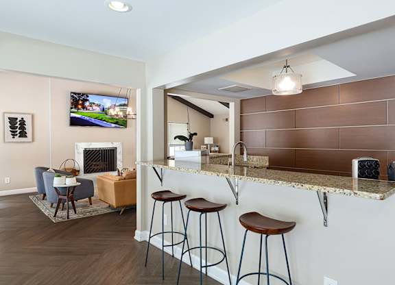 A living room with a fireplace and a bar area.