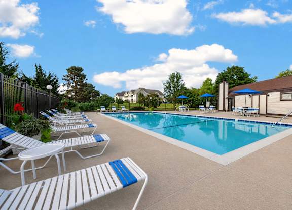 A pool with blue and white lounge chairs.