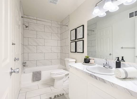 A white bathroom with a toilet, sink, and shower.