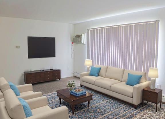 A living room with a couch, chairs, and a coffee table.