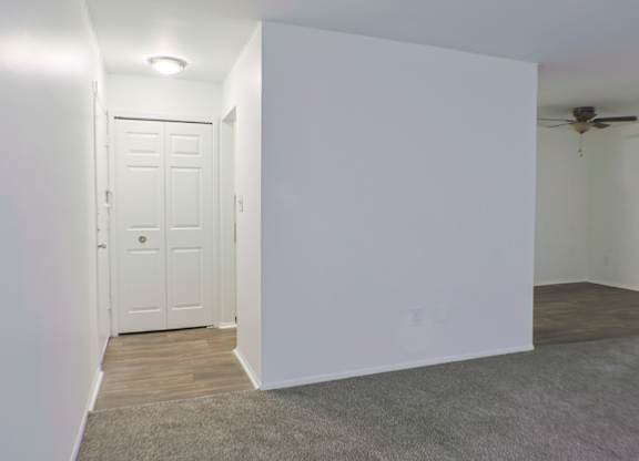 A white door is in a room with a ceiling fan.
