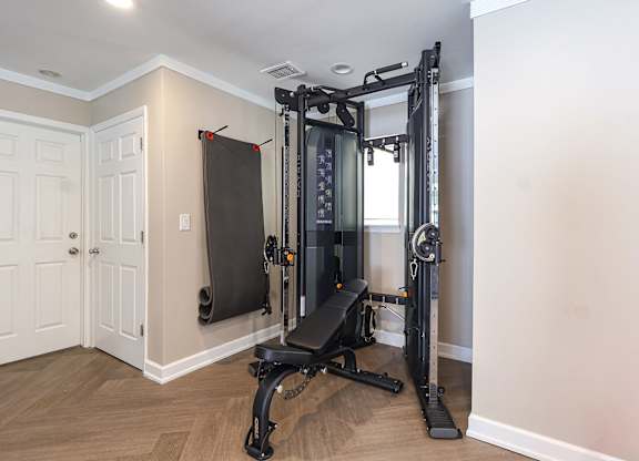 A home gym with a squat rack, bench, and weights.