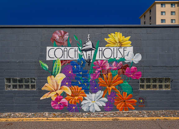 A mural of flowers surrounds the words
