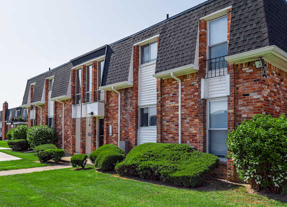 A row of red brick houses with white windows and doors.