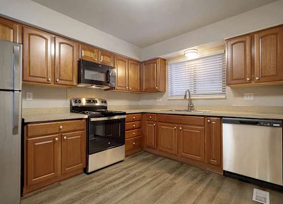 A kitchen with wooden cabinets and stainless steel appliances.