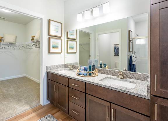 A bathroom with brown cabinets and a marble countertop.