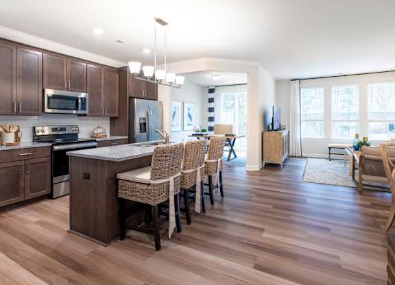 A kitchen with brown cabinets and a wooden floor.