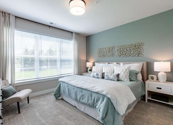 a bedroom with a bed and a large window