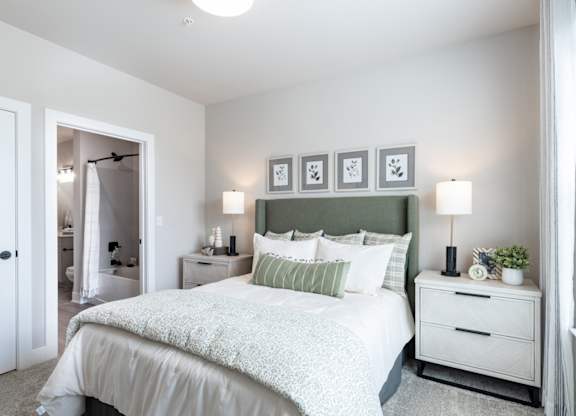 a bedroom with a bed and two nightstands and a wall with a painting