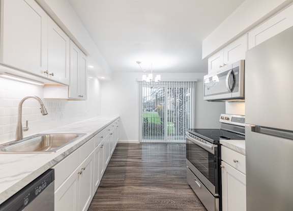 A kitchen with white cabinets and a black stove top oven.