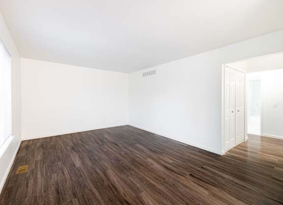 A room with wooden flooring and white walls.