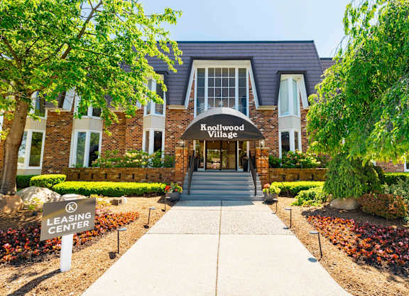 The entrance to Knollwood Village with a leasing center sign in front.