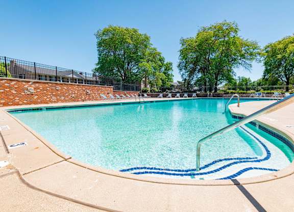 A large outdoor swimming pool with a blue line in the middle.