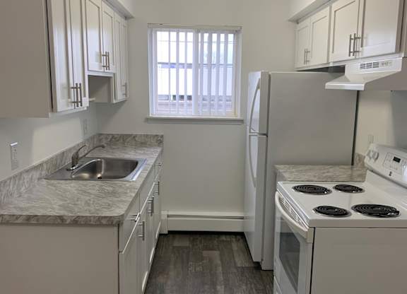 A kitchen with white appliances and cabinets.