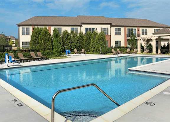 a large swimming pool with a hotel in the background