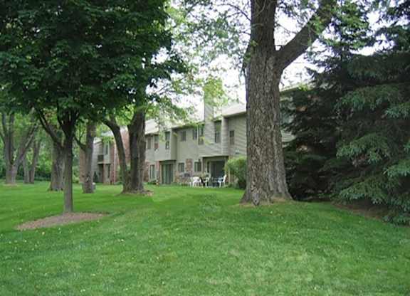 a large yard with trees and a house in the background