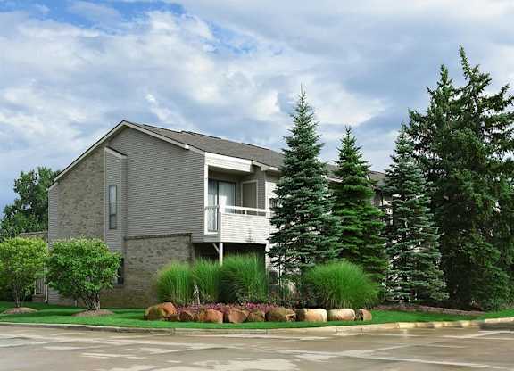 a house with a parking lot and some trees
