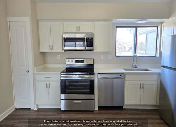 A kitchen with white cabinets and stainless steel appliances.