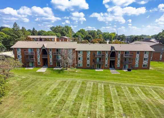 A large, multi-story building with a green lawn in front.