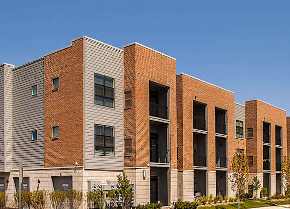 A long row of modern red brick apartment buildings.