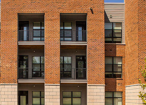 A red brick building with balconies and windows.