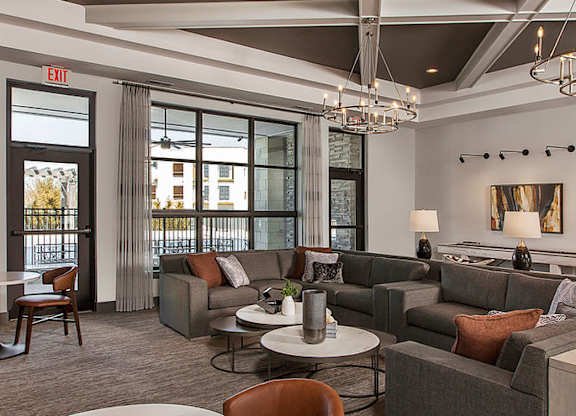 A large, modern living room with a fireplace and a view of the outside.