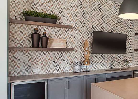 A kitchen with a brown table and grey cabinets.