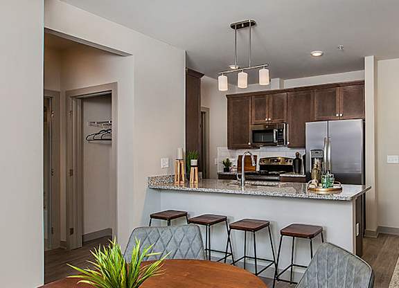 A kitchen with a bar stool and a table.