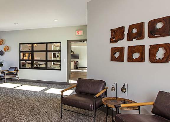 A room with brown chairs and a brown couch.