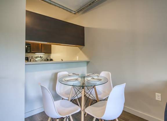 A kitchen with a table and chairs.