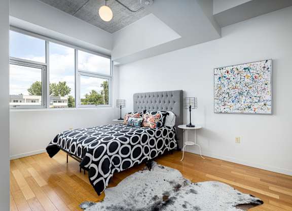 A bedroom with a large bed and a painting on the wall.